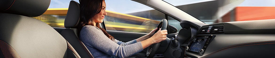 A woman driving a 2024 Nissan Versa in Medina, OH